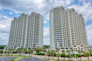 two tall white buildings in a parking lot at Ariel Dunes I in Destin