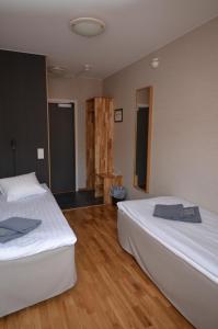 a hotel room with two beds and a table at Hotell Svanen in Kalmar