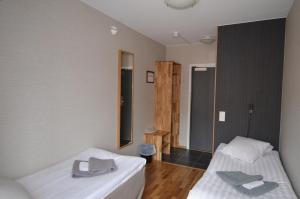 
a bedroom with a bed and a dresser at Hotell Svanen in Kalmar
