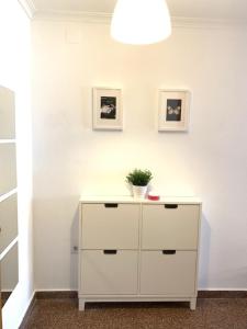 a white dresser with a plant on top of it at UIM Mediterraneo Diagonal 17 Wifi in Puerto de Sagunto