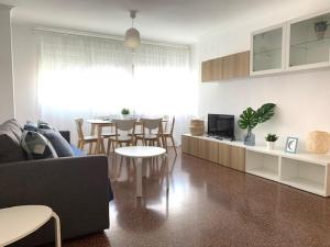 a living room with a couch and a dining room at UIM Mediterraneo Diagonal 17 Wifi in Puerto de Sagunto +12 photos