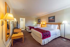 Rúm í herbergi á Canada's Best Value Desert Inn & Suites