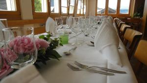 a long table with wine glasses and flowers on it at Hotel Gebidem in Visperterminen