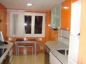 a small kitchen with a table and a window at PISO ALISAL CON GARAJE in Santander
