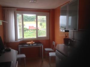 a kitchen with a table and a window and a desk at PISO ALISAL CON GARAJE in Santander