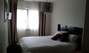 um quarto com uma cama grande e uma janela em PISO ALISAL CON GARAJE em Santander