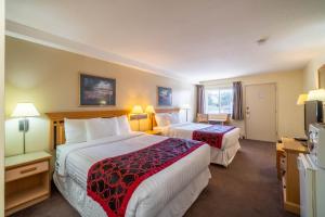 Rúm í herbergi á Canada's Best Value Desert Inn & Suites