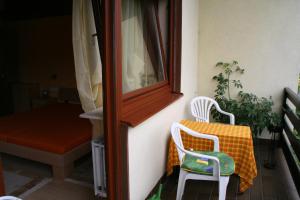 a pair of chairs sitting on a porch with a window at Ferienhaus Susanne in Haßloch