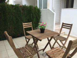 einem Holztisch mit zwei Stühlen und einer Topfpflanze in der Unterkunft Ideal house at the Beach in Sagunto(Valencia) in Sagunt