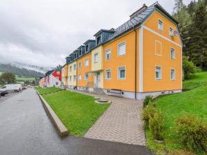 a large yellow building on a street next to a road at Apartment in St Lambrecht near ski area in Sankt Lambrecht