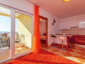 a kitchen with an orange curtain and a table with chairs at Beautiful Apartment in Dramalj in Dramalj
