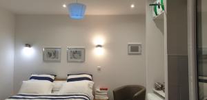a white room with a bed and two pillows at Dominicaine Sud, Studio meublé in Amilly