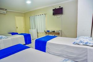 a room with three beds and a tv on the wall at Exclusive Hotel in Petrolina +3 photos