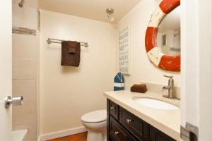La salle de bains est pourvue d'un lavabo, de toilettes et d'un miroir. dans l'établissement Waikiki Place Studios at The Marine Surf Waikiki, à Honolulu
