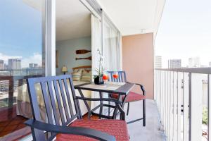 a balcony with a table and chairs on a balcony at Waikiki Place Studios at The Marine Surf Waikiki in Honolulu