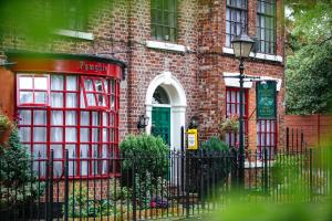 a brick building with a green door and a telephone booth at Pymgate Lodge Hotel Manchester Airport in Cheadle