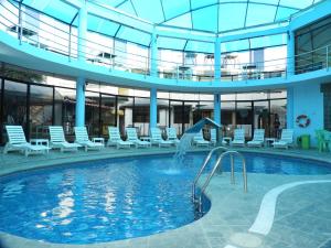 a swimming pool with a slide in a building at Arenas Hotel & Spa in Tacna
