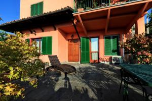 a patio with a bench and a building with green shutters at Felicin - Villa Stella in Monforte dʼAlba