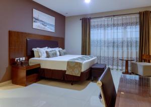 una camera con un grande letto e una finestra di Frederick's Lodge a Kumasi