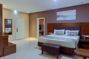 1 dormitorio con 1 cama grande y 1 mesa en Frederick's Lodge en Kumasi