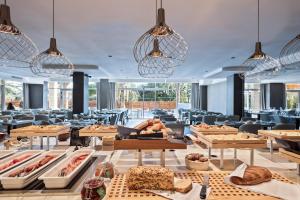 a restaurant with tables and chairs and lights at Hotel AMI Budva Petrovac in Petrovac na Moru