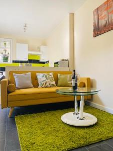 sala de estar con sofá amarillo y mesa en Pine Lodge en Gillingham