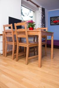 een houten eettafel en stoelen met bloemen erop bij Marymont in Warschau