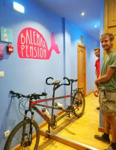 a man standing next to two bikes in a room at Balenax Pensión in Gijón