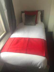 a red and white bed in a room at Kirubash Central Pier Hotel in Blackpool