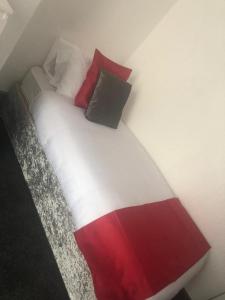 a bed with red white and black pillows on it at Kirubash Central Pier Hotel in Blackpool