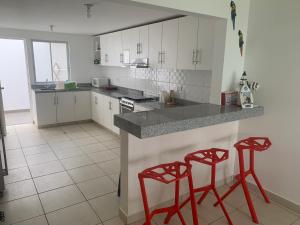 eine Küche mit zwei roten Stühlen an der Theke in der Unterkunft La Casa del Jota in Asia