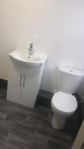a bathroom with a white toilet and a sink at Kirubash Central Pier Hotel in Blackpool