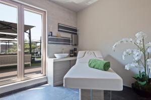 a bathroom with a white chair and a sink at Hotel AMI Budva Petrovac in Petrovac na Moru