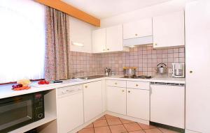 eine Küche mit weißen Schränken und einer Arbeitsplatte in der Unterkunft Residence Cesa Callegari in Wolkenstein in Gröden