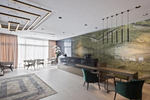 a dining room with tables and chairs and a wall at Hotel AMI Budva Petrovac in Petrovac na Moru