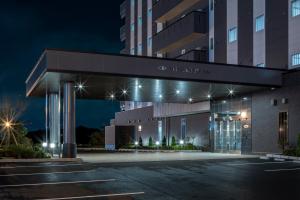 - une vue sur l'avant de l'hôtel la nuit dans l'établissement Hotel Route-Inn Kamisu, à Kamisu