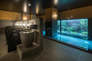 a bathroom with a swimming pool and a bathroom with at Hotel Route-Inn Kamisu in Kamisu