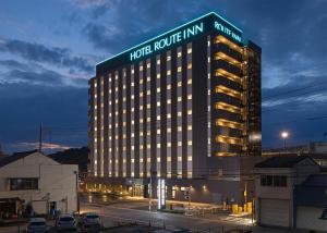 a hotel building with a sign on top of it at Hotel Route-Inn Hamada Ekimae in Hamada