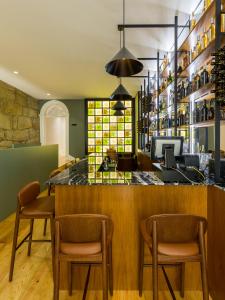 a bar in a restaurant with chairs and a counter at Gallery Hostel in Porto
