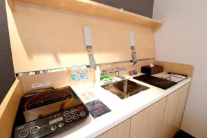 a small kitchen with a sink and a stove at Stay SAKURA Kyoto Fuga in Kyoto