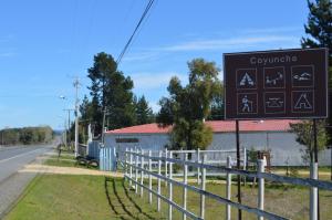 a sign on the side of a road next to a fence at Coyunche Cabañas y Camping Laja & San Rosendo in Laja