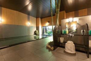 a bathroom with a swimming pool next to a swimming pool at Hotel Route-Inn Osaka Kishiwada -Higashikishiwada Ekimae Kansai Airport- in Kishiwada