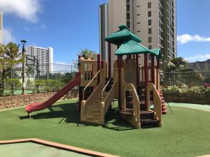 einen Spielplatz mit Rutsche auf dem Rasen in der Unterkunft Waikiki Banyan Bliss, Ocean View & Walk to Beach in Honolulu