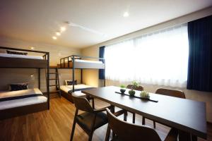 東京的住宿－RoNa Hotel，客房设有餐桌和双层床。
