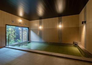 a room with a swimming pool with a large window at Hotel Route-Inn Ichihara in Ichihara