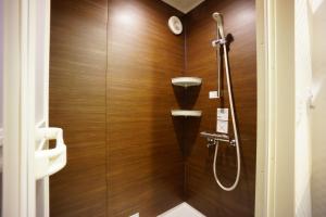 a bathroom with a shower with wooden walls at RoNa Hotel in Tokyo