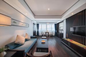 sala de estar con sofá azul y mesa en Howard Johnson Sandalwoods Resort Huizhou, en Huidong