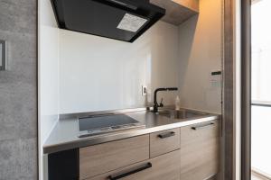 a kitchen with a sink and a stove at HOTEL All Stay Hakata Kukodori in Fukuoka