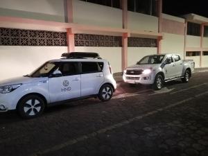 two vehicles parked in front of a building at Hostal El Pinzón in Puerto Ayora