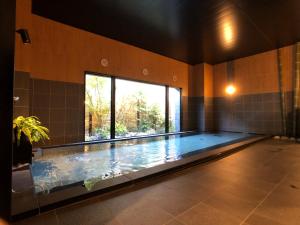 - une grande piscine dans une chambre dotée d'une grande fenêtre dans l'établissement Hotel Route-Inn Yamanashi Chuo, à Chuo